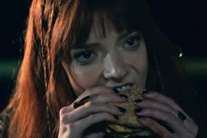 Anya Taylor-Joy eating a cheeseburger as Margot in The Menu