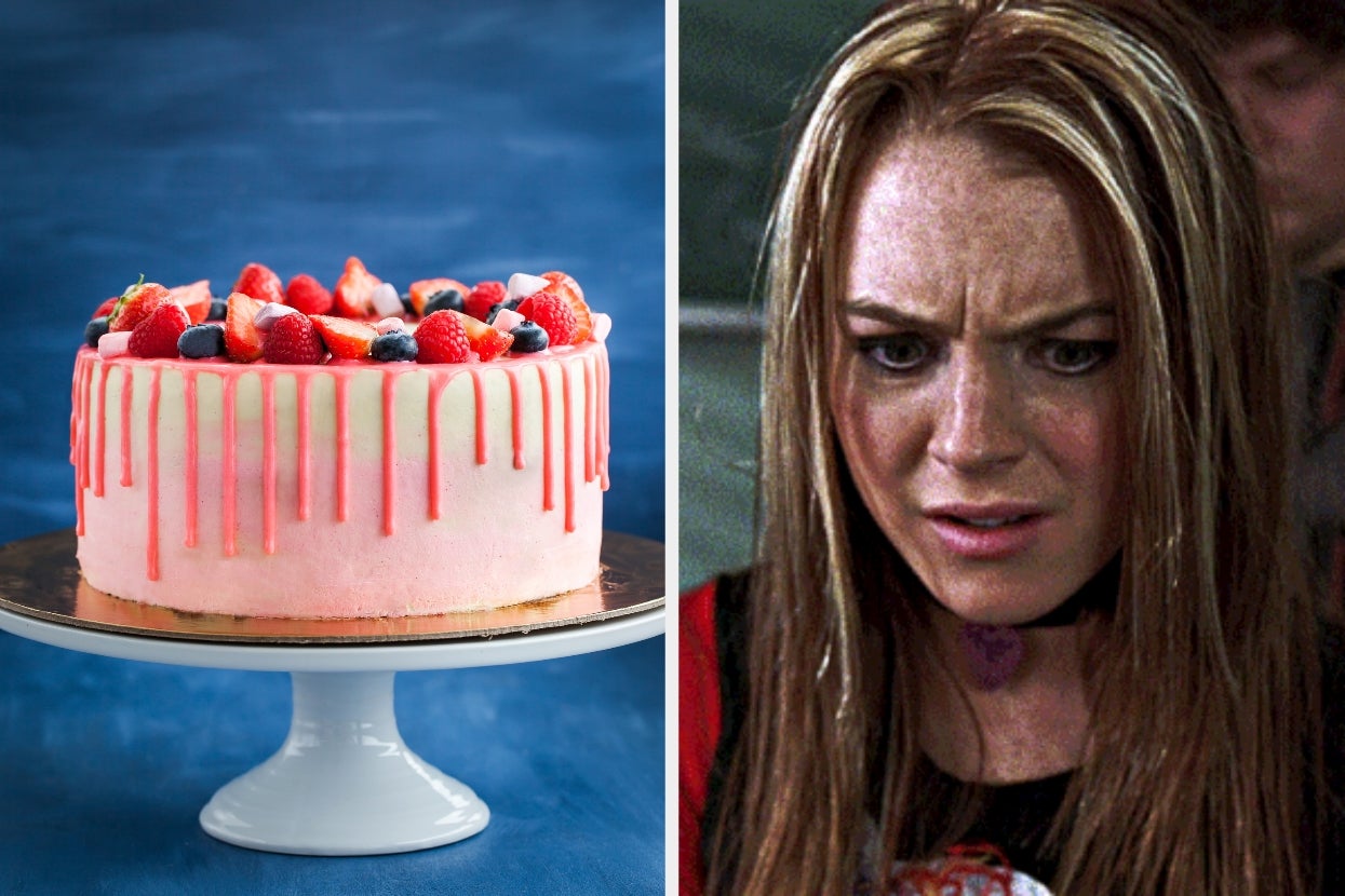 A pink drip cake topped with berries on a stand next to a person looking puzzled or concerned
