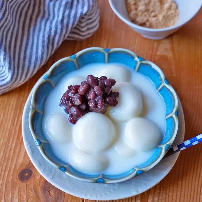 和風の小鉢に載った牛乳白玉ぜんざいに、あんこときな粉が添えられたスイーツ。
