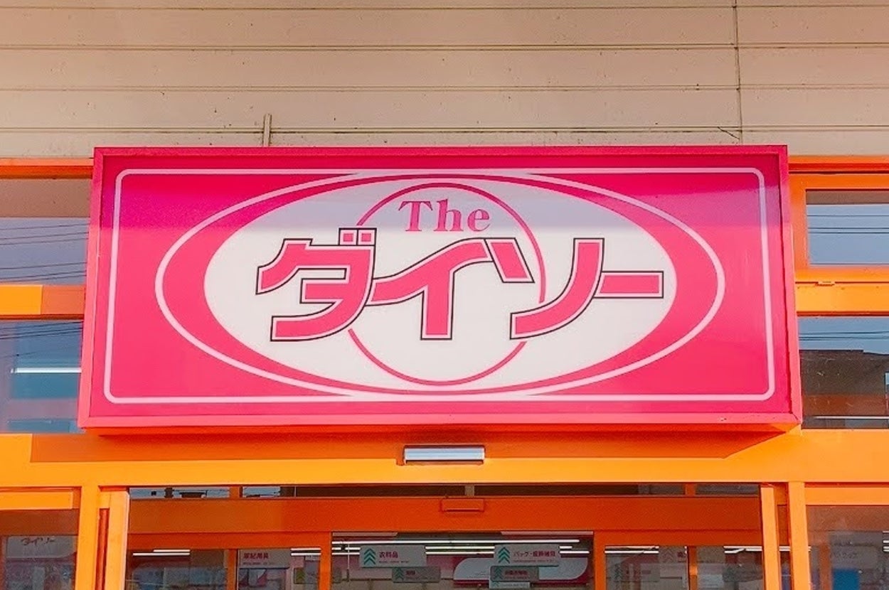 「Theダイソー」の店舗入口。看板が上に掲げられており、多くの商品が並んでいる店内が見える。