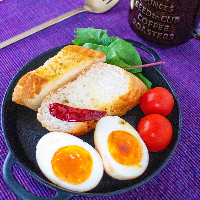 パン、半熟卵、トマト、野菜、唐辛子が並ぶ朝食プレート。
