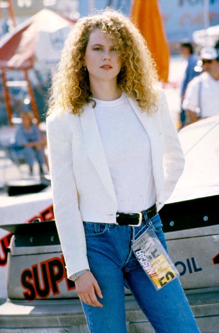 Nicole Kidman with curly hairsbreadth successful a achromatic blazer and jeans stands successful beforehand of a racing car