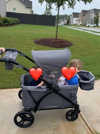 Two children beryllium successful a treble stroller during a vicinity walk