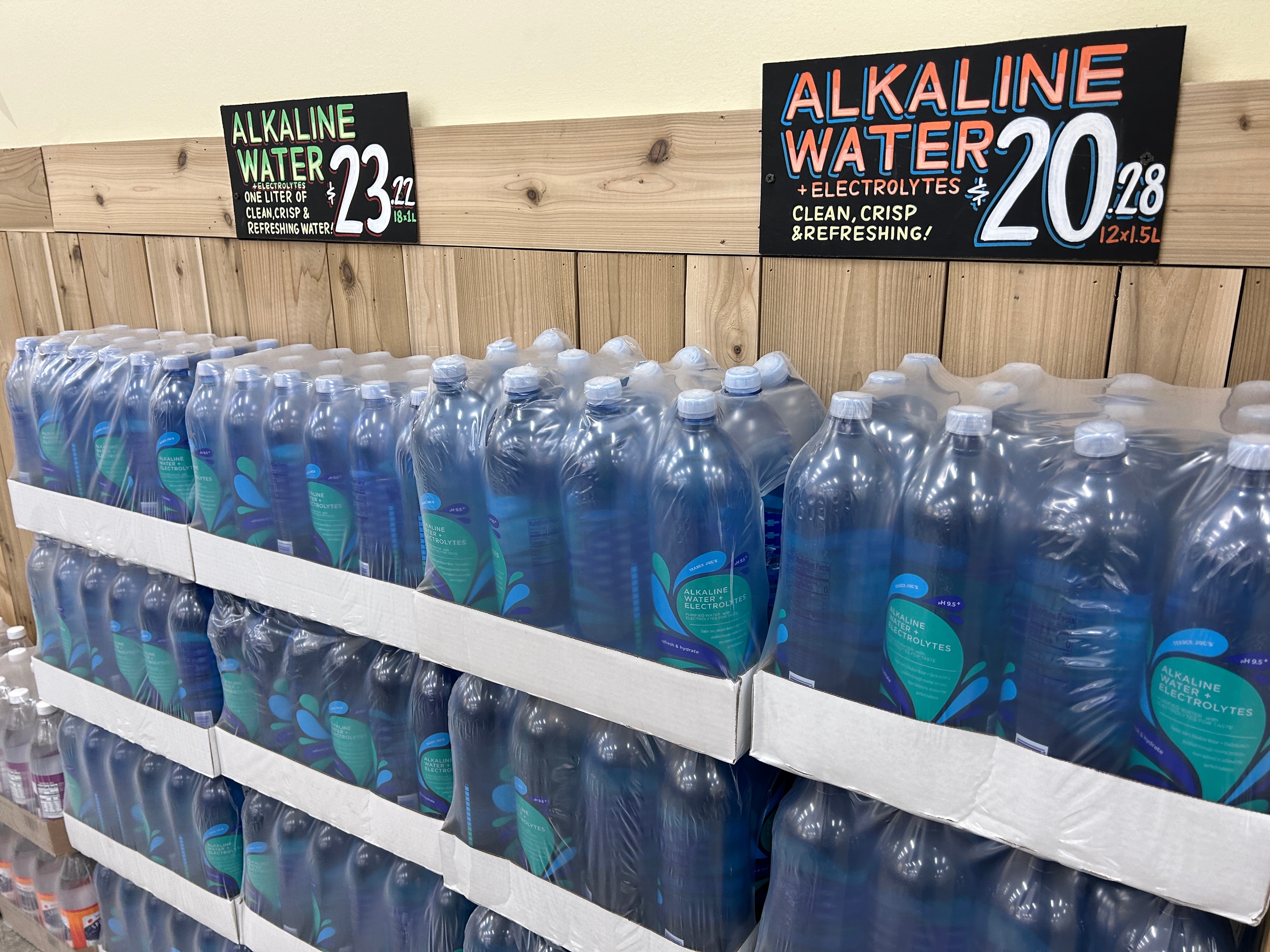 Flasker med alkalisk vann vises i trehyller med en prislapp på 20,28 for en 12-pakke på 1,5-liters flasker