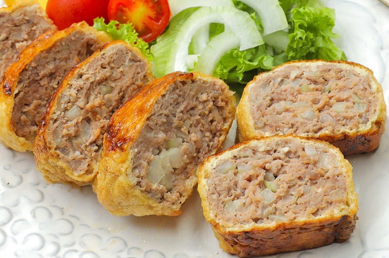 皿に盛られたハンバーグの切り身とレタス、トマト、玉ねぎのスライス。