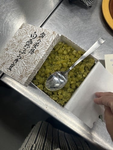 スプーンが刺さった箱入りのドライフルーツのような食品。箱には花柄の模様がある。