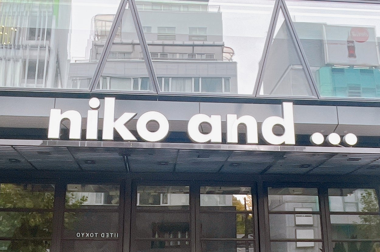 「niko and ...」店舗の外観。モダンなガラス張りの建物で、入り口の看板には店名。