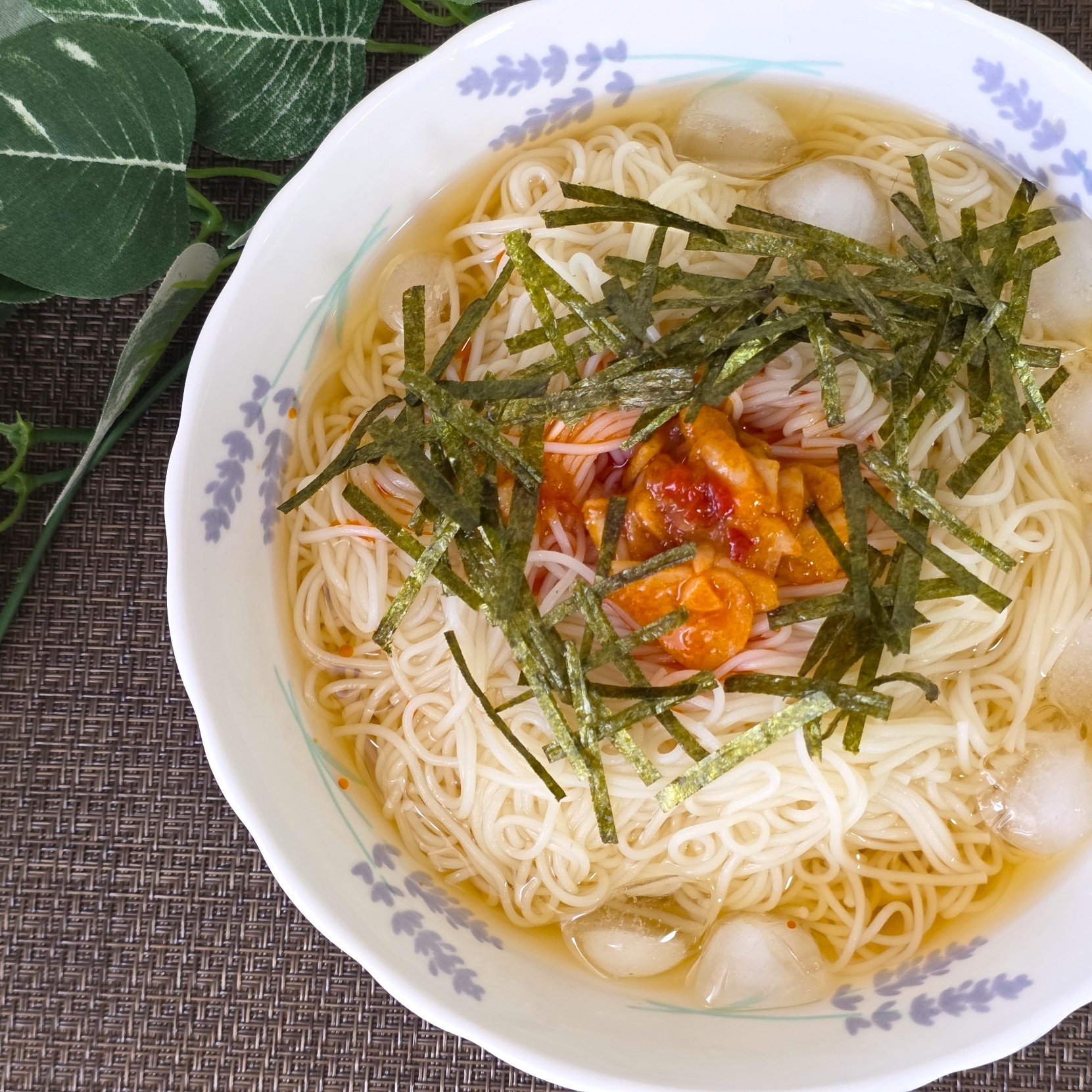 和風の冷やし素麺に刻み海苔と何かをトッピングした料理が器に盛られている。