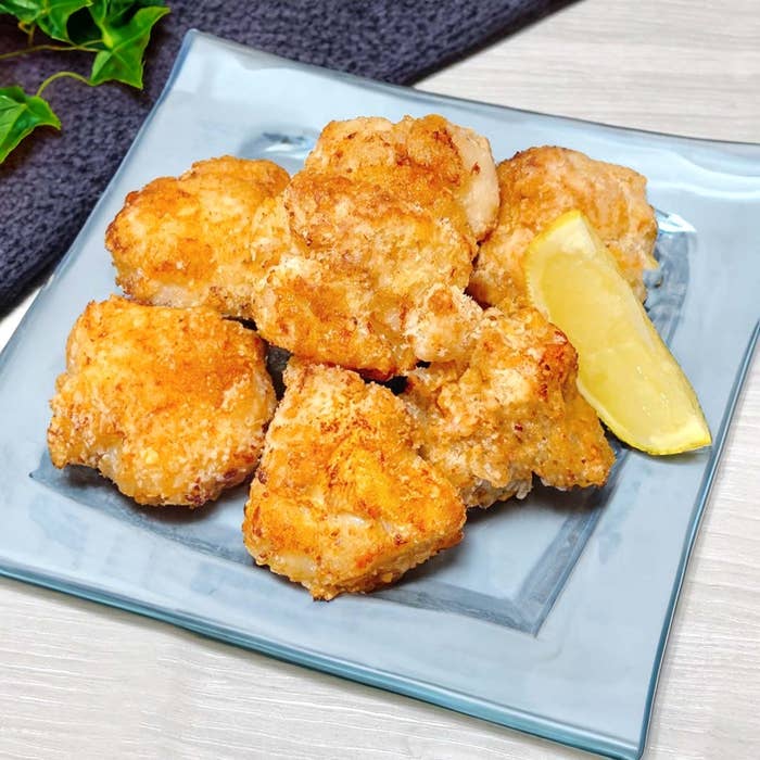 お皿に盛られた揚げた鶏肉の唐揚げとレモンのスライス。