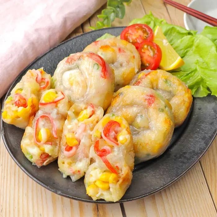 皿に盛られた野菜が入った餃子。トマトとレタスが添えられている。