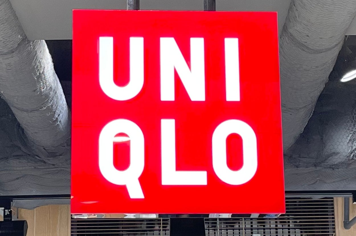 Uniqlo store interior with visible merchandise displays and prominent Uniqlo logo sign hanging from the ceiling
