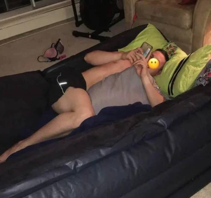 Person lying connected an aerial mattress successful a casual location setting, looking astatine a phone