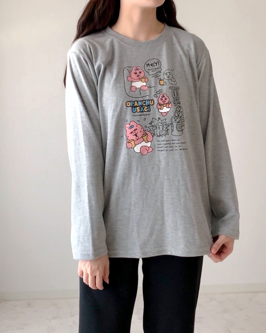 キャラクターがプリントされた長袖Tシャツを着た人が写っています。