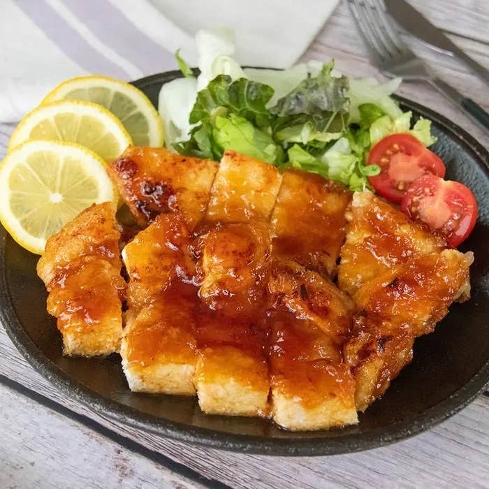 レモンとサラダ添えの揚げチキンに甘辛ソースがかかった料理。