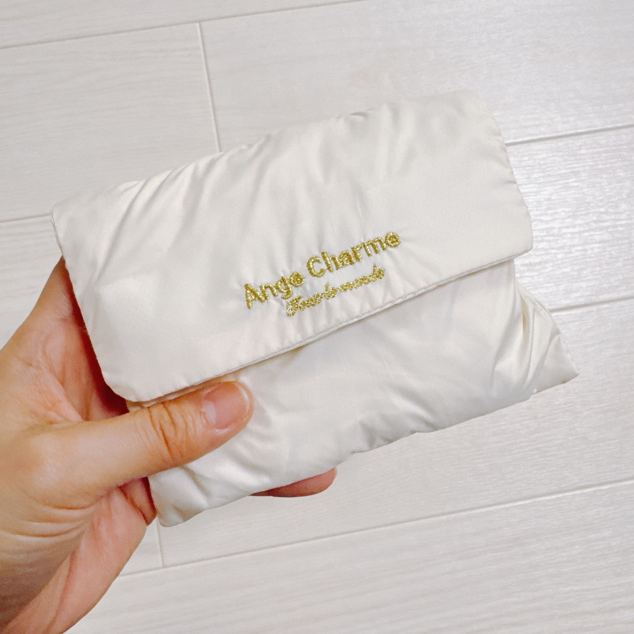 手に持った小さな折りたたみ袋。表面に「Ange Charme」と刺繍されています。