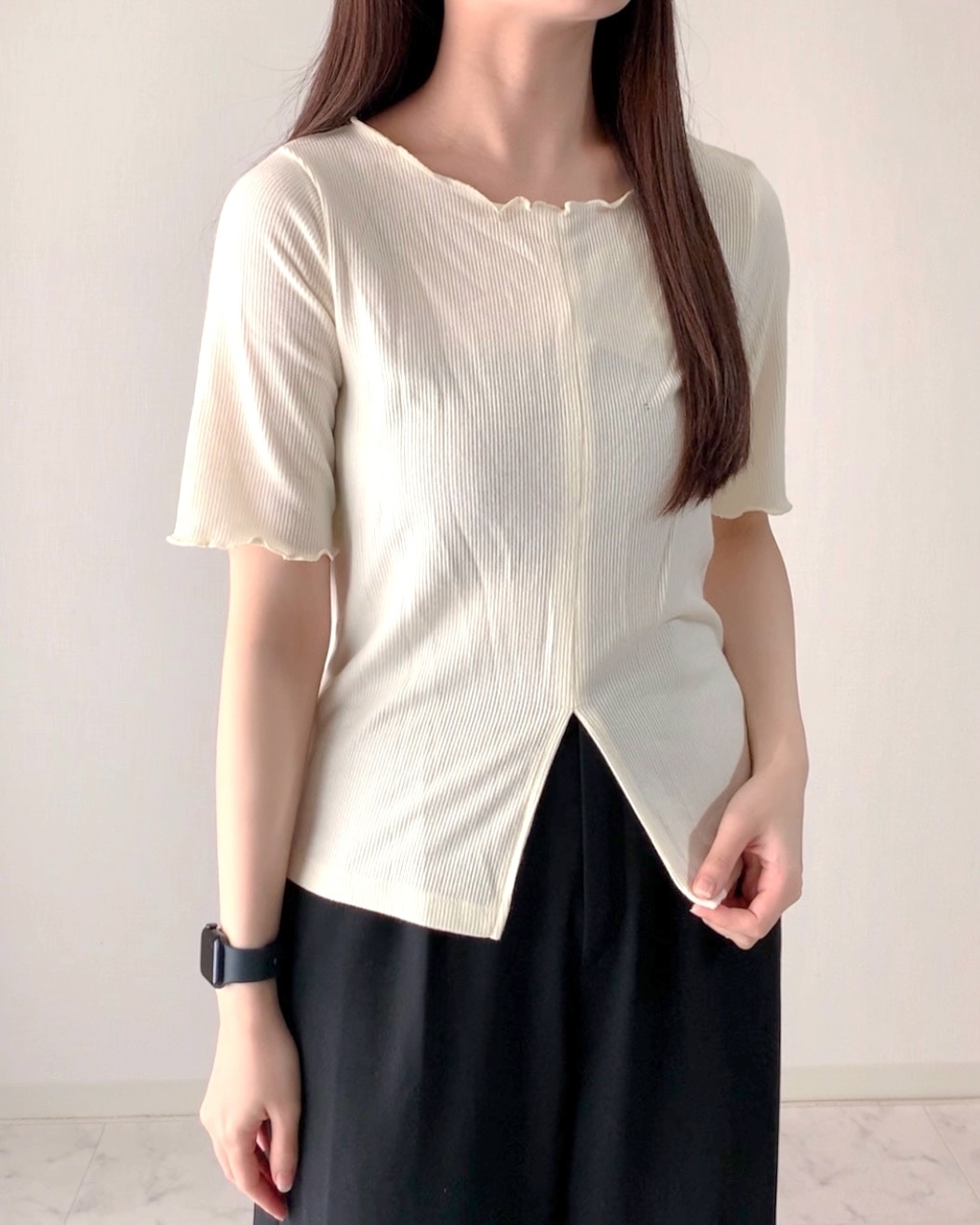 女性が短い袖のリブシャツとロングスカートを着ています。シャツは裾がスリットになっています。