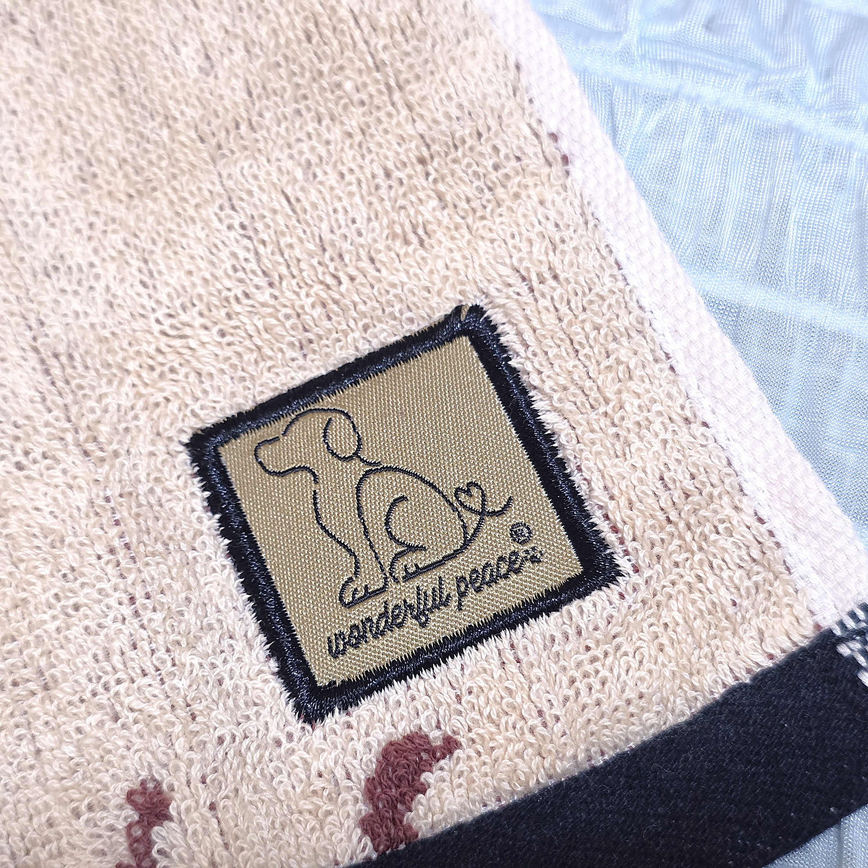 犬のシルエットと「wonderful peace」のロゴが入った布製アイテム。