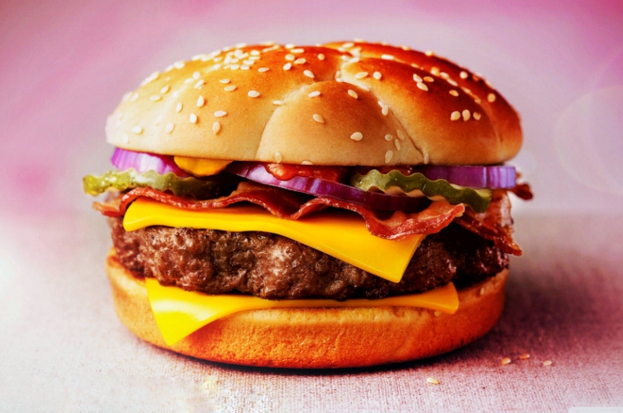 Cheeseburger with bacon, pickles, onions, and lettuce on a sesame seed bun