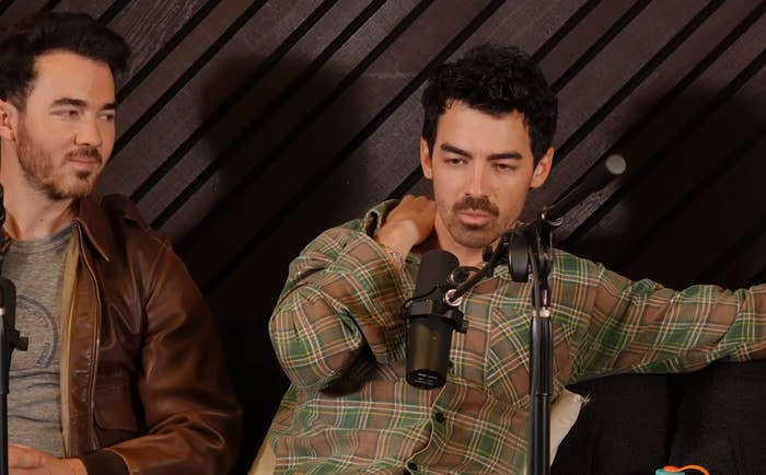 Kevin and Joe Jonas are seated successful beforehand of microphones connected a podcast