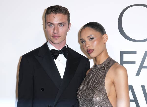 Lucky Blue Smith in a black tuxedo and Nara Smith in a sparkly, sleeveless dress pose together at an event