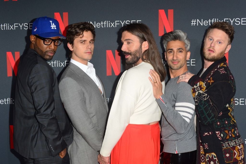 Five individuals pose playfully at a Netflix event, dressed in stylish, diverse outfits