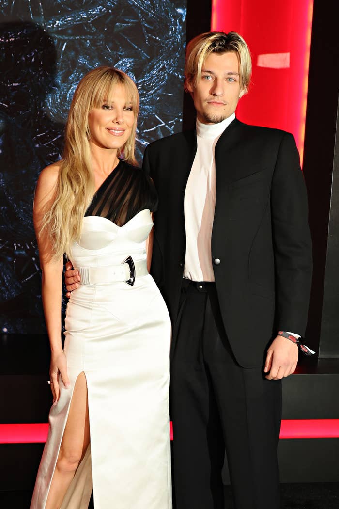 Millie Bobby Brown and Jake Bongiovi airs connected the reddish carpet. One wears a achromatic strapless gown with a slit, the different a stylish achromatic and achromatic suit