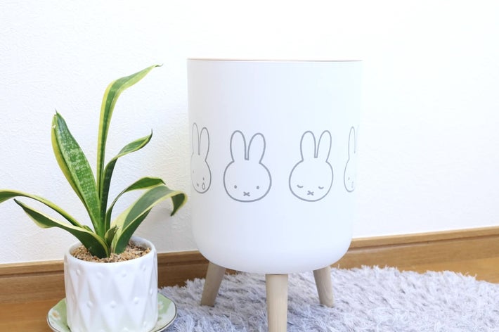 鉢植えの植物とウサギのイラストが描かれた丸い脚付きの白い鉢。