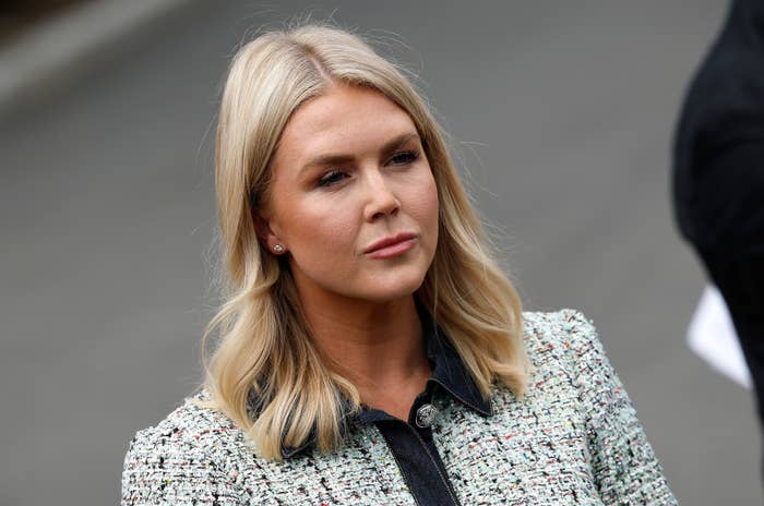 Person with shoulder-length hairsbreadth wearing a textured jacket, lasting outdoors with a focused expression