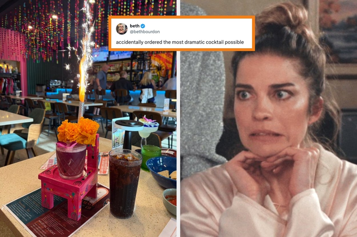 A restaurant table with a cocktail served with sparklers and a startled woman's expression beside it. Tweet: "accidentally ordered the most dramatic cocktail possible."
