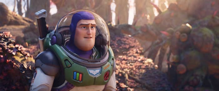 A space ranger character, wearing a futuristic suit with a clear helmet, stands in a lush, alien landscape