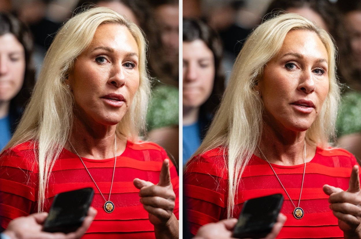 Person with long hair speaks to media, wearing striped attire and a pendant necklace