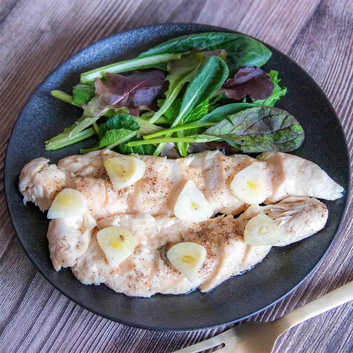 皿に盛られた調理済みの鶏肉と新鮮なサラダ。