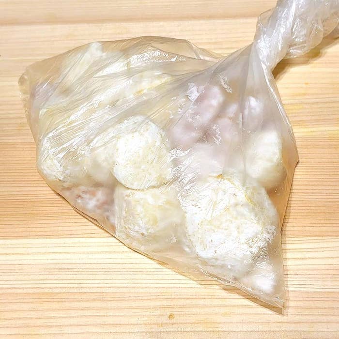 ビニール袋に入った食品が木の板の上に置かれている。