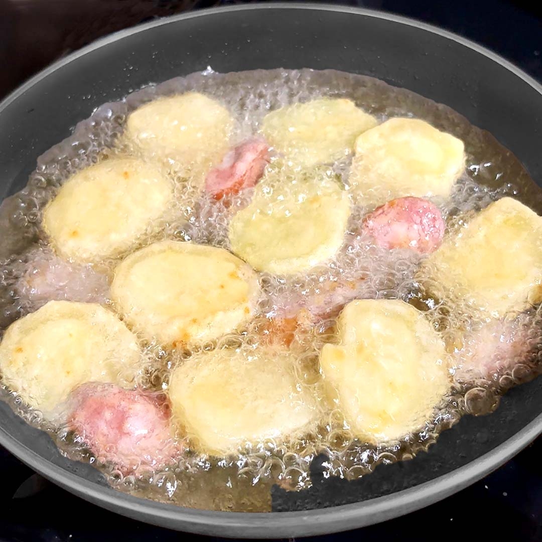 泡が立ち熱せられた油の中で料理が進行中。