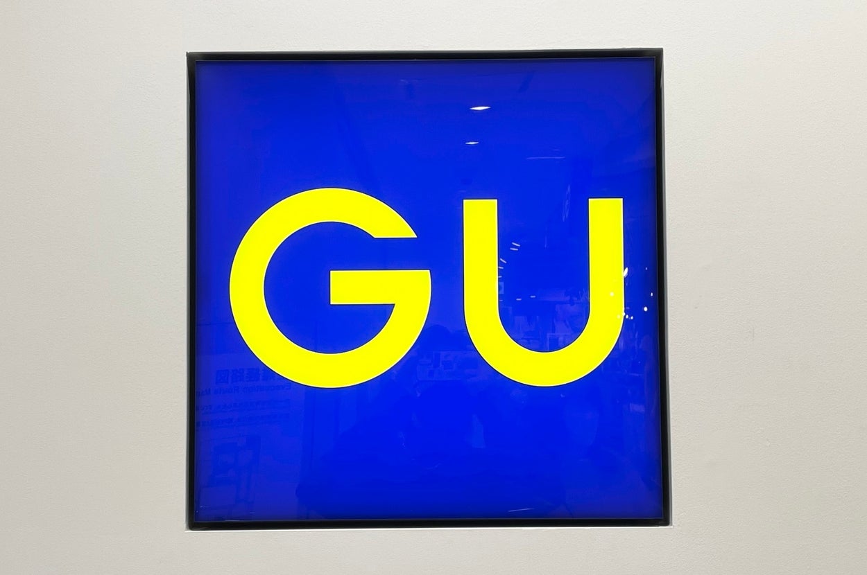 Store sign with large "GU" letters on a bright background