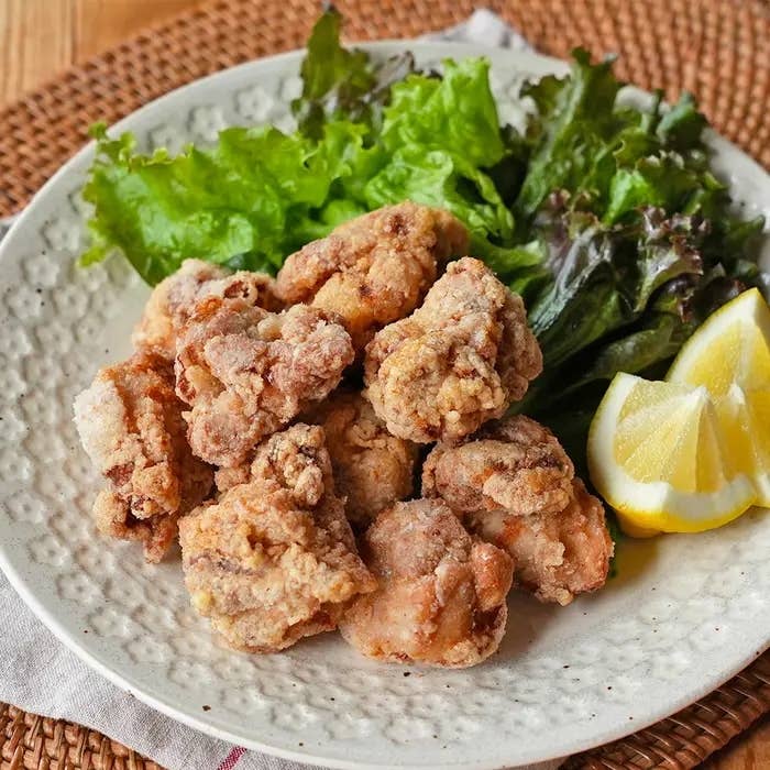 お皿に盛り付けられた唐揚げとレタス、レモンのスライスが添えられている。