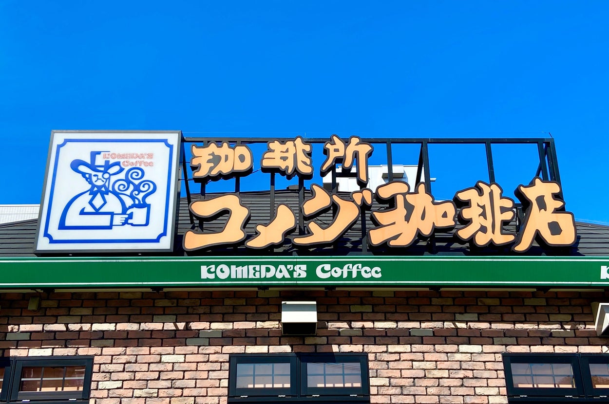 コメダ珈琲店の店舗外観。レンガ造りの建物で屋根に大きな看板があり、店名が表示されています。