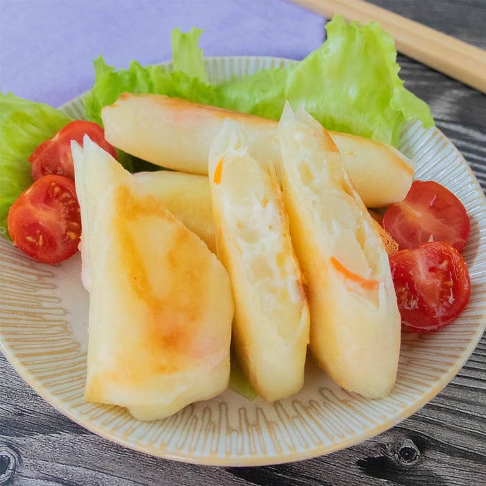 春巻きとトマトが盛り付けられた皿。春巻きは半分にカットされ、中にポテトサラダとチーズが詰められている。