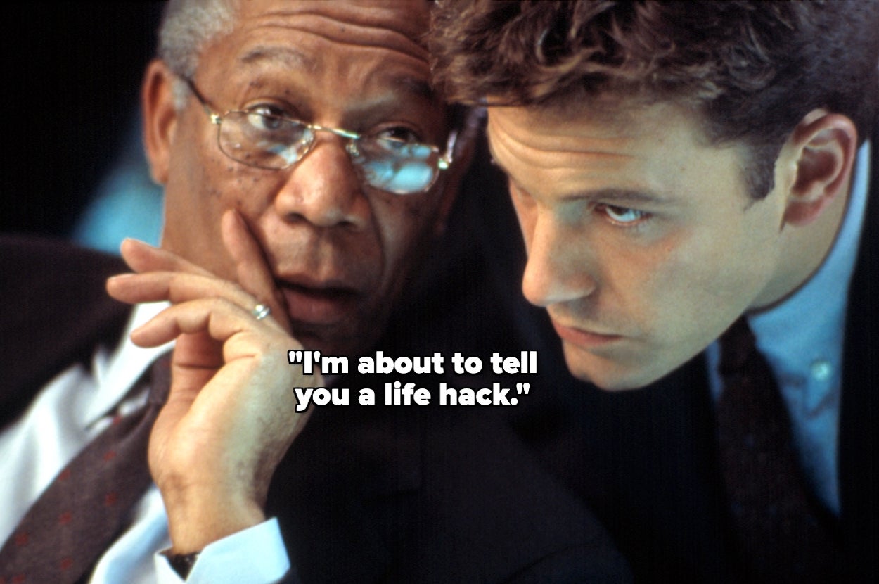 Two men in suits are huddled closely; one is facing forward with a hand near his mouth, as if whispering to the other. Text reads: "I'm about to tell you a life hack."