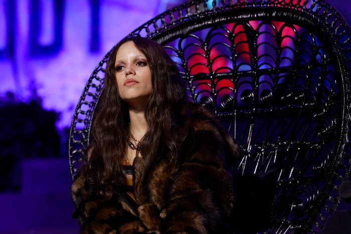 Person with agelong hairsbreadth successful a faux fur overgarment sits connected an intricate achromatic chair, looking contemplative