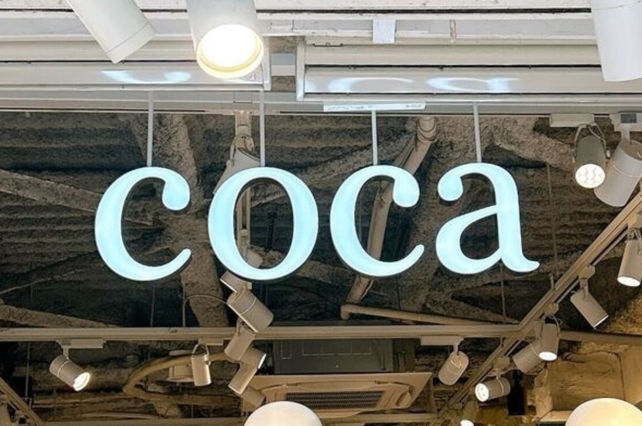 店内の天井から吊るされた「coca」という看板。店内にマネキンが並んでいる。