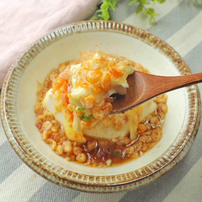 盛られた豆腐の和食が木製スプーンですくわれている。美味しそうで健康的な料理。