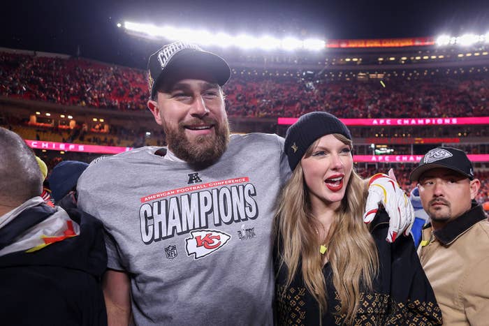 A shot subordinate wearing a "Champions" garment and chapeau stands smiling with a pistillate successful a beanie among a cheering assemblage successful a stadium