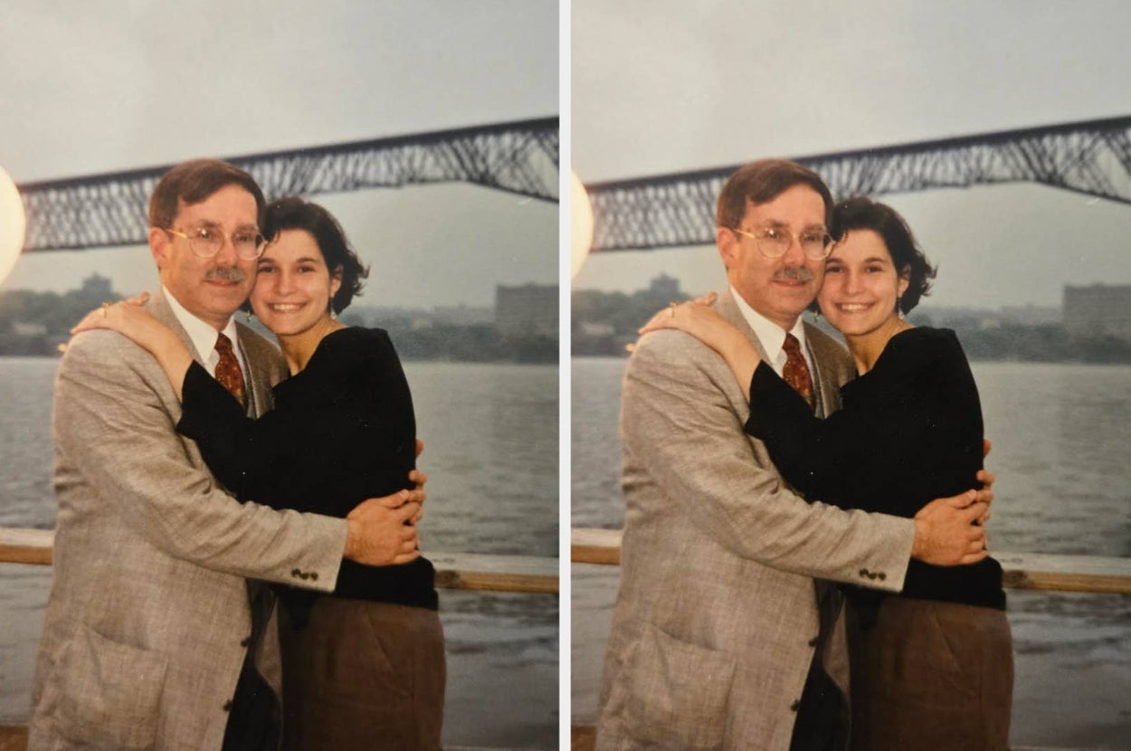 Two people smile and pose for a photo by a waterfront with a bridge in the background. They are embracing and appear happy