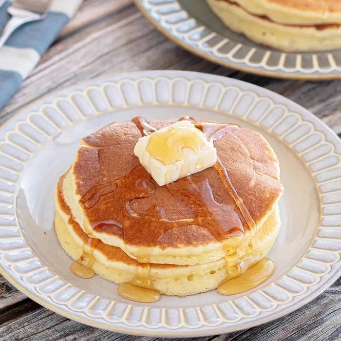 パンケーキ2枚にバターとシロップがかかった朝食シーン。