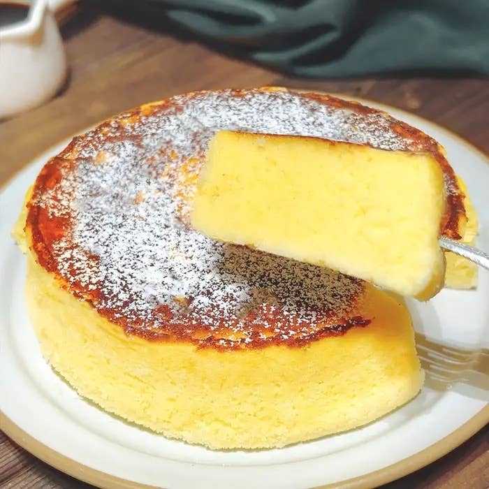 フワフワのチーズケーキが皿に盛られ、スライスされています。砂糖がかかっています。
