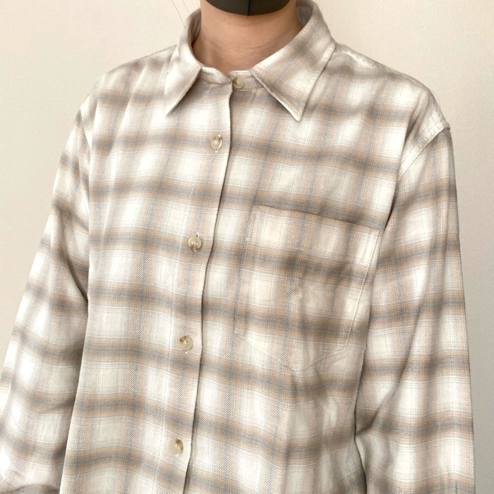Person wearing a plaid button-up shirt