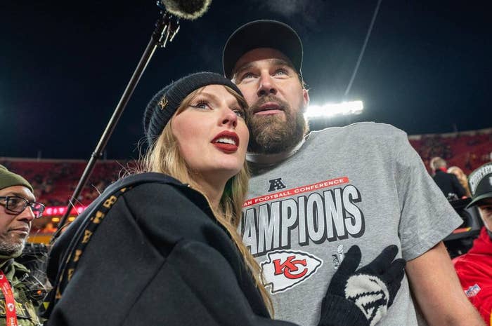 A vocalist successful casual deterioration and a antheral successful a "Champions" T-shirt basal connected a sports tract astatine night, surrounded by onlookers