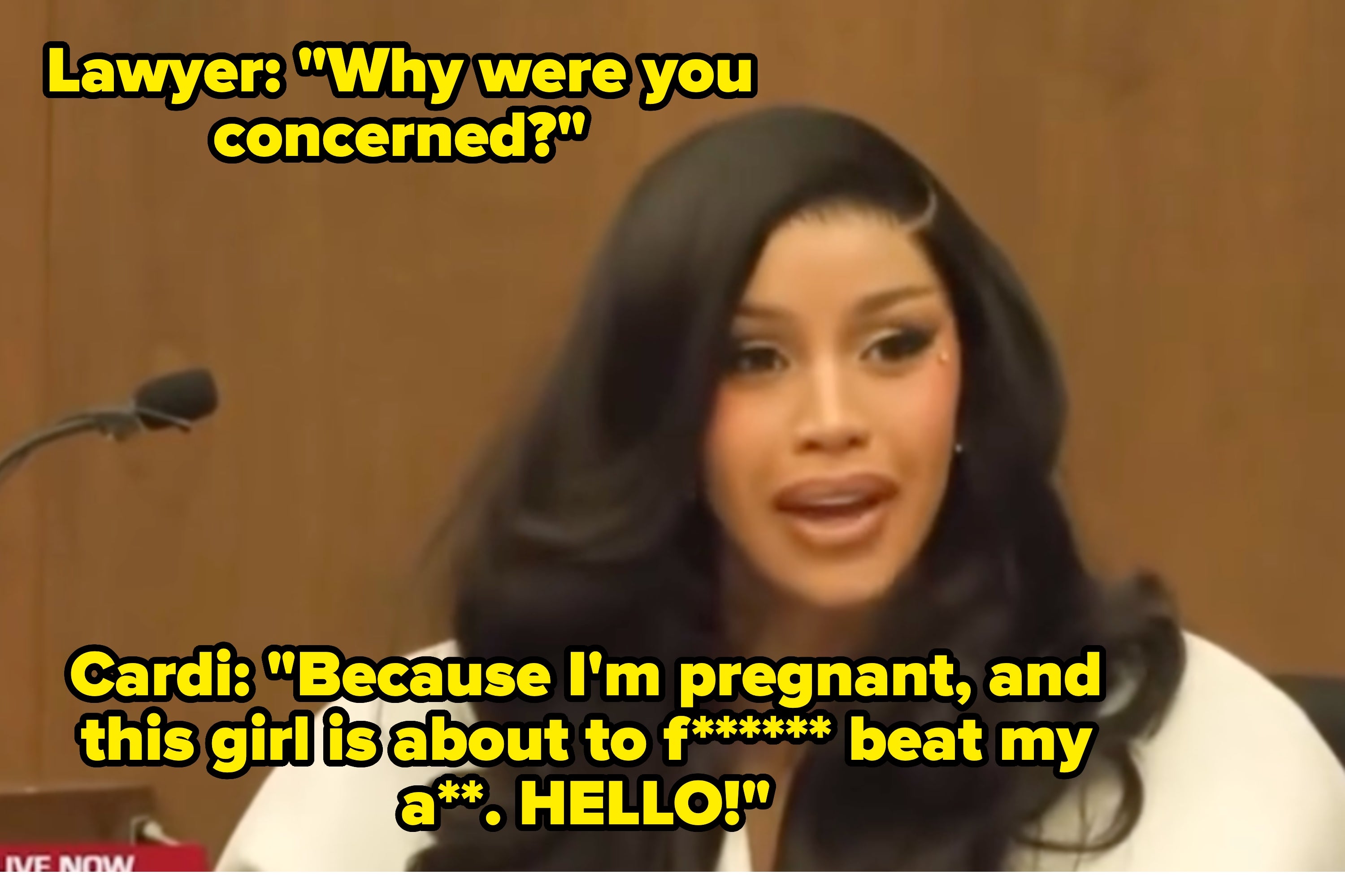 Cardi B seated in a courtroom setting, wearing a chic outfit with voluminous hair and speaking into a microphone