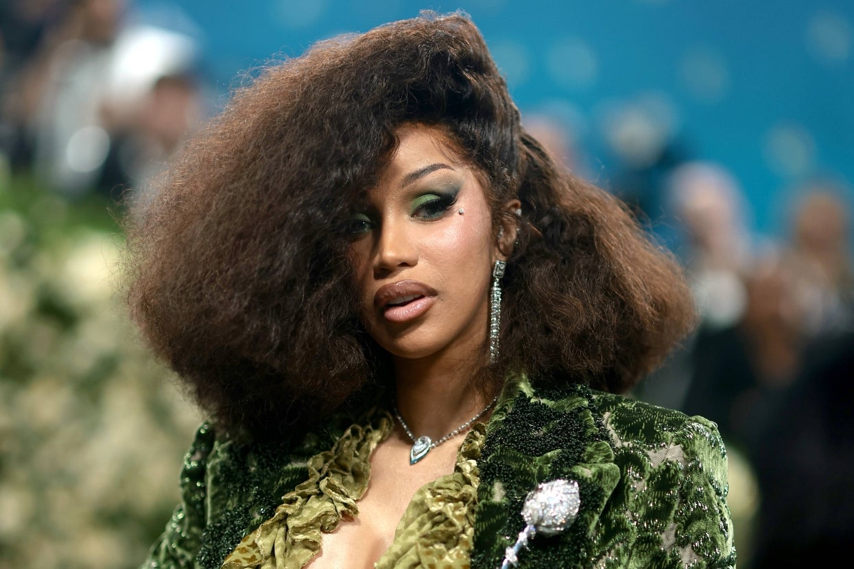 Cardi B in a luxurious textured gown with voluminous hair and statement jewelry poses at a high-profile event